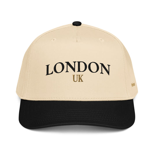 Two-tone cream and black London embroidered cap featuring gold UK accent and Worldmark logo — refined British minimal style.