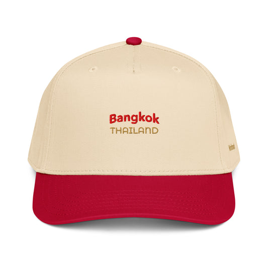 Two-tone cream and red Bangkok embroidered cap featuring gold “Thailand” text and Worldmark logo — inspired by Thai culture and vibrant street energy.